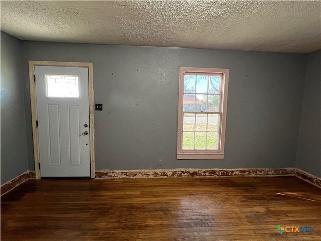 entrance foyer with dark hardwood / wood-style flooring and a textured ceiling