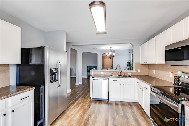 kitchen featuring white cabinetry, appliances with stainless steel finishes, sink, and kitchen peninsula