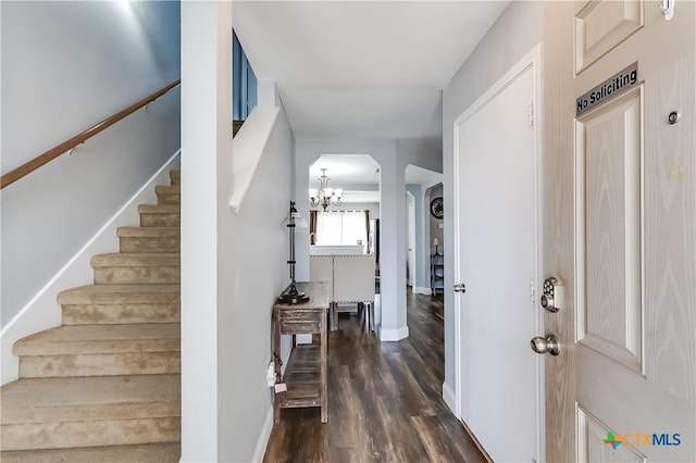 entrance foyer featuring dark hardwood / wood-style floors and a notable chandelier