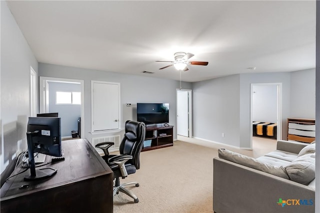 carpeted office space with ceiling fan