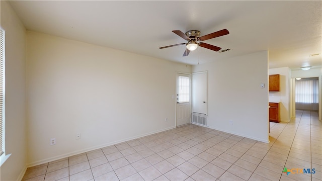 spare room with ceiling fan and light tile patterned floors