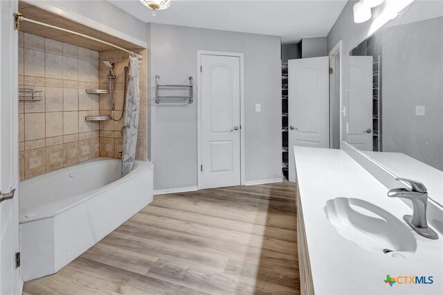 bathroom featuring vanity, wood-type flooring, and shower / tub combo with curtain