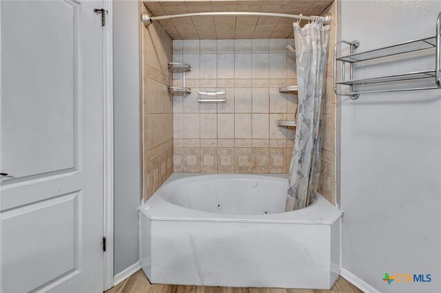 bathroom with wood-type flooring and shower / bath combination with curtain