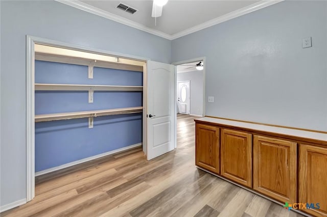 interior space featuring light wood-type flooring, ceiling fan, and crown molding