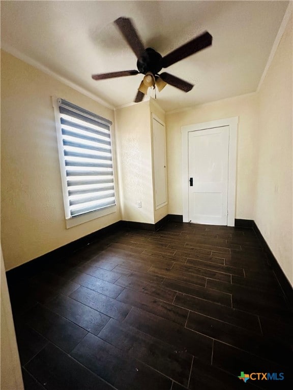 spare room with dark hardwood / wood-style flooring, ceiling fan, and crown molding