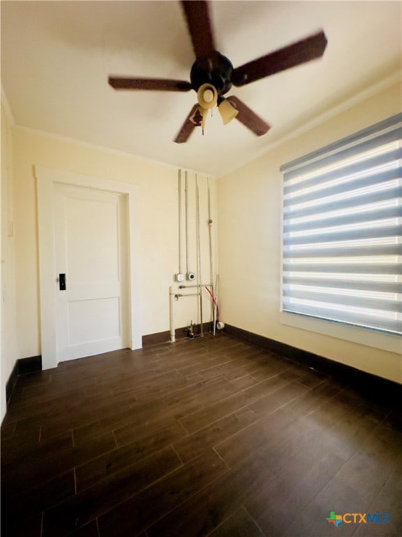 empty room with ceiling fan and dark hardwood / wood-style flooring