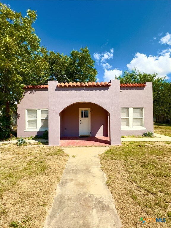 mediterranean / spanish-style house with a front yard