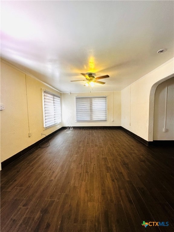 empty room featuring ceiling fan and dark hardwood / wood-style flooring