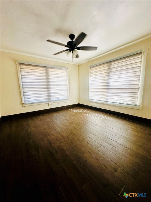 empty room featuring dark hardwood / wood-style flooring, ceiling fan, and crown molding