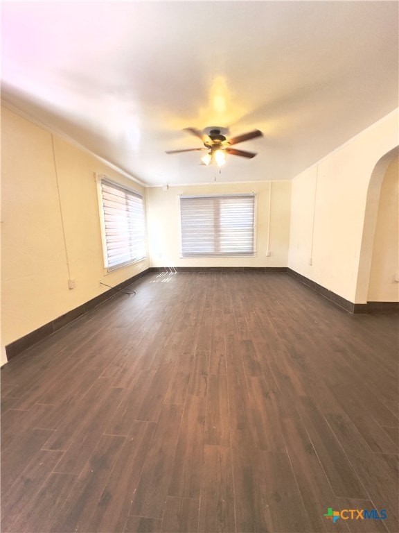 spare room with dark wood-type flooring and ceiling fan