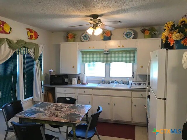 kitchen with white cabinetry, sink, ceiling fan, a textured ceiling, and white fridge