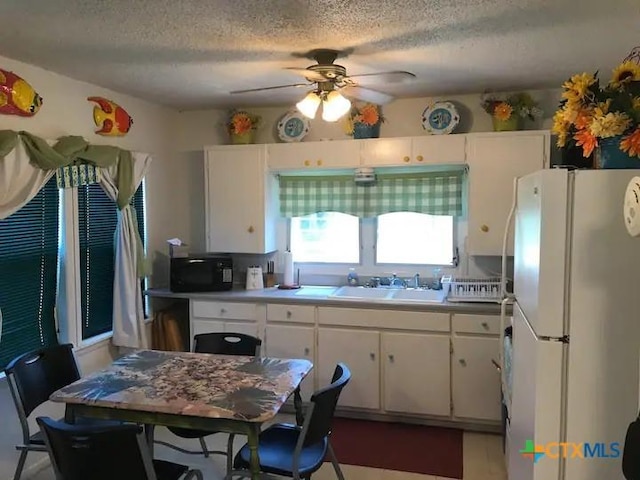 296 S Ocean Dr, Port Lavaca, TX 77979 - kitchen featuring freestanding refrigerator, white cabinetry, ceiling fan, a textured ceiling, and black microwave