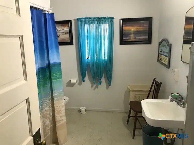 bathroom with toilet and concrete flooring