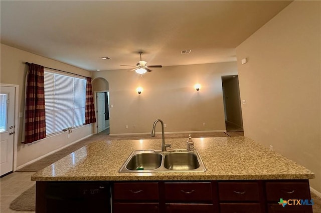 1205 Abbey Rdg, Temple, TX 76504 - kitchen with black dishwasher, a ceiling fan, open floor plan, dark brown cabinetry, and an island with sink