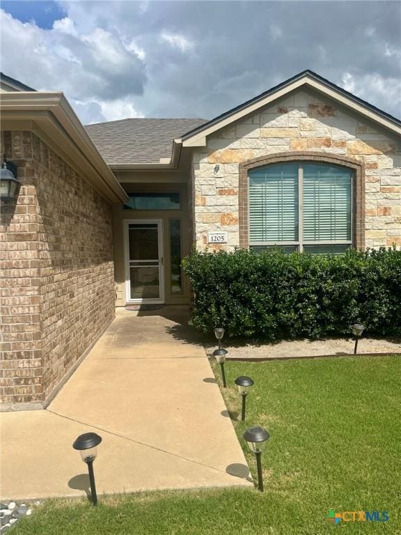 1205 Abbey Rdg, Temple, TX 76504 - entrance to property with a lawn, brick siding, stone siding, and a patio area