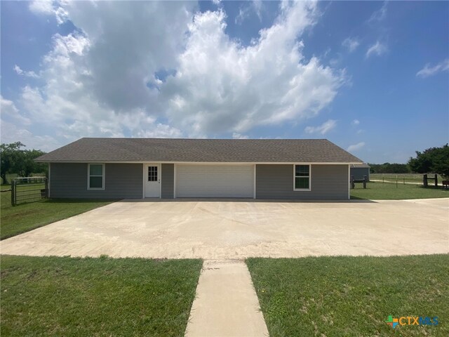 ranch-style home with fence, an attached garage, driveway, and a front lawn