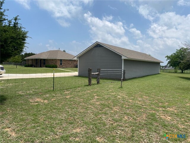 view of property exterior with a lawn and fence