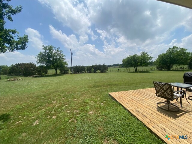 view of yard with a rural view and a wooden deck