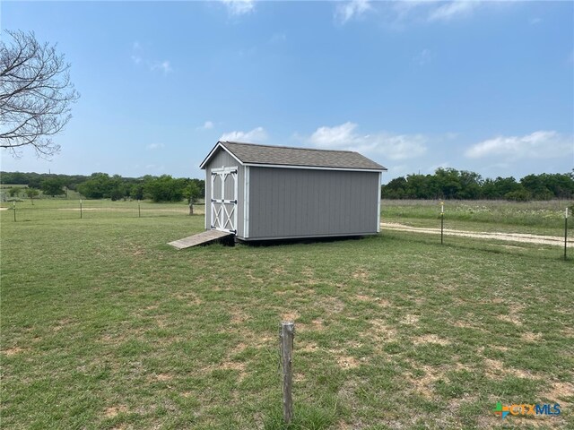 view of yard with a storage unit, an outbuilding, and a rural view