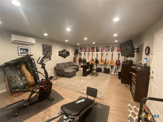 workout room featuring a wall mounted AC, recessed lighting, and wood finished floors