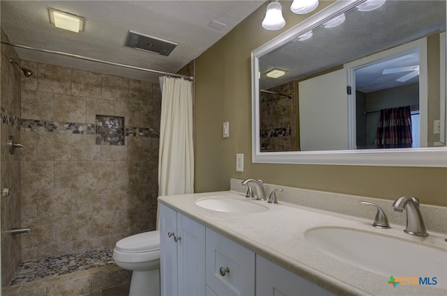 bathroom featuring a textured ceiling, curtained shower, toilet, and vanity