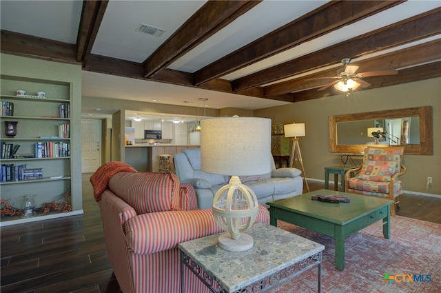 living room featuring ceiling fan, built in shelves, and beamed ceiling