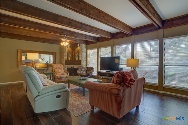 living room featuring ceiling fan, a brick fireplace, and beam ceiling