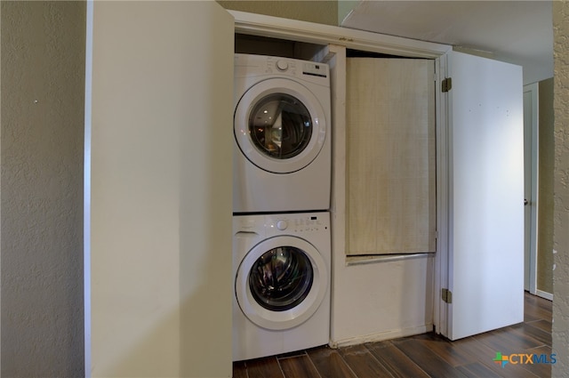 washroom featuring stacked washer / dryer and dark hardwood / wood-style flooring