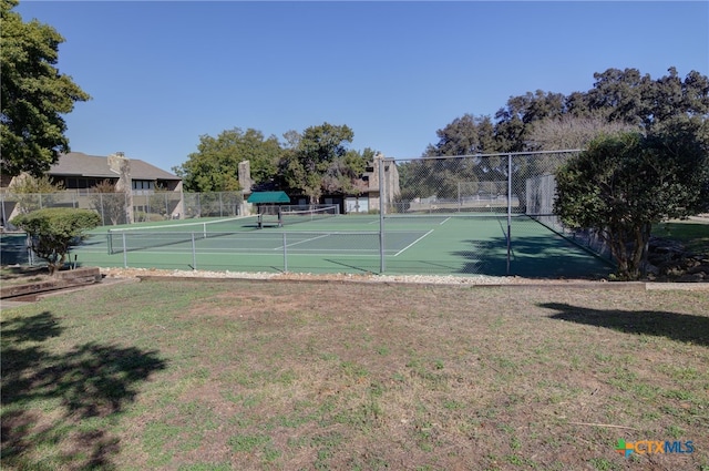 view of tennis court featuring a yard