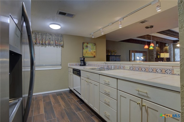 kitchen featuring pendant lighting, white cabinets, stainless steel refrigerator with ice dispenser, sink, and white dishwasher