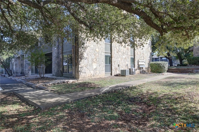 view of property exterior featuring cooling unit and a lawn