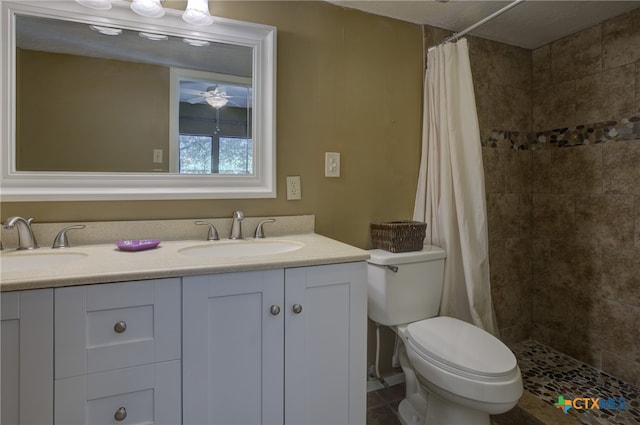 bathroom with toilet, walk in shower, ceiling fan, and vanity