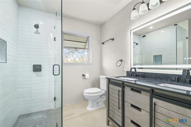 bathroom featuring toilet, tile patterned floors, a shower with shower door, and vanity