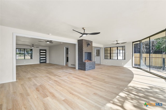 unfurnished living room with light wood-type flooring and a fireplace