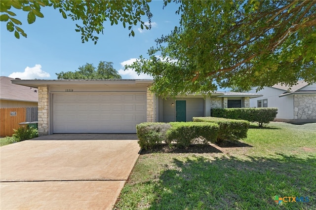 12219 Mosley Ln, Austin, TX 78727 - single story home with stone siding, an attached garage, driveway, and a front lawn