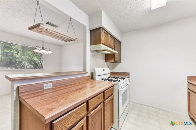 12219 Mosley Ln, Austin, TX 78727 - kitchen with white range with gas cooktop, under cabinet range hood, a textured ceiling, pendant lighting, and brown cabinetry