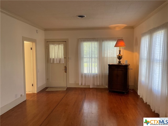 doorway to outside featuring dark wood-type flooring, plenty of natural light, and ornamental molding