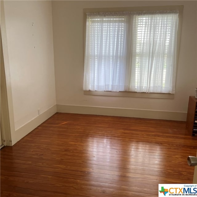 empty room with hardwood / wood-style flooring