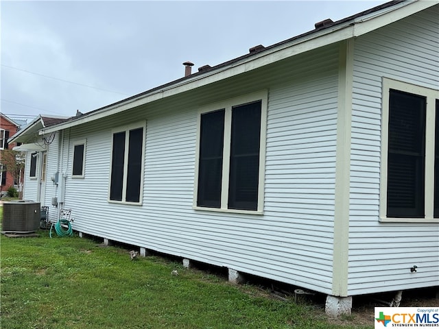 view of property exterior featuring cooling unit and a yard