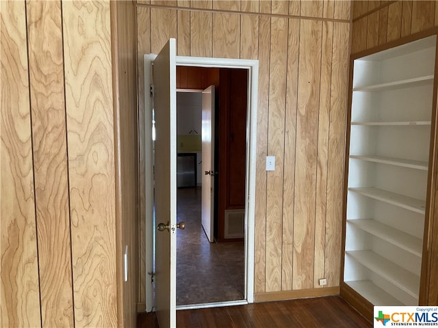 corridor featuring wooden walls and dark hardwood / wood-style floors