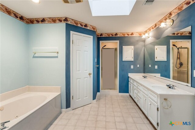 820 California Blvd, New Braunfels, TX 78130 - bathroom with a skylight, a whirlpool tub, a stall shower, double vanity, and baseboards