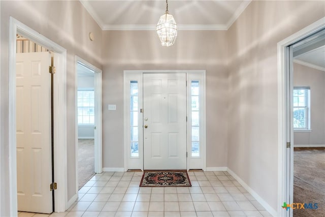 820 California Blvd, New Braunfels, TX 78130 - foyer with crown molding, a chandelier, light colored carpet, light tile patterned flooring, and baseboards