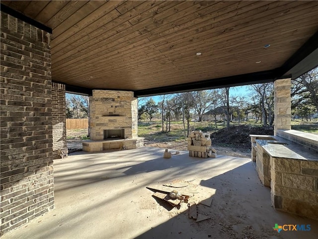 view of patio / terrace featuring an outdoor stone fireplace