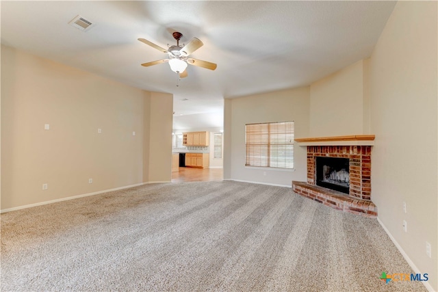 unfurnished living room featuring light carpet, ceiling fan, and a fireplace