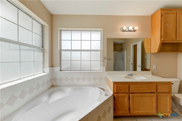 full bathroom featuring toilet, tile patterned flooring, and plenty of natural light