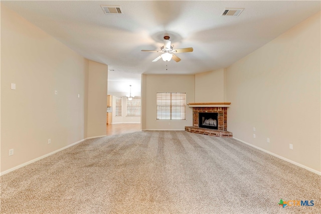 unfurnished living room with a fireplace, carpet floors, and ceiling fan