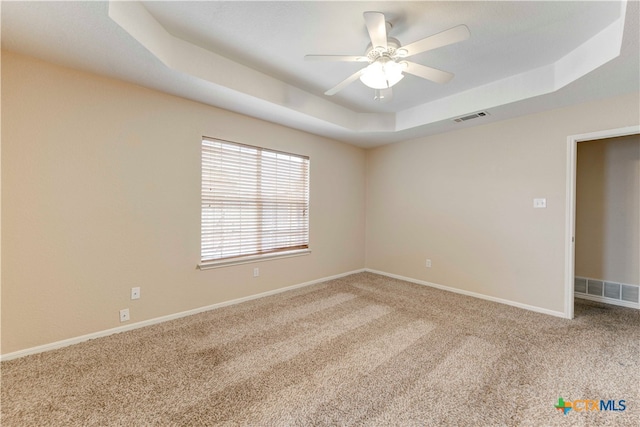 unfurnished room with carpet floors, ceiling fan, and a tray ceiling