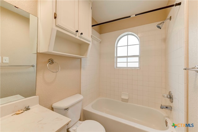 full bathroom featuring vanity, tiled shower / bath combo, and toilet