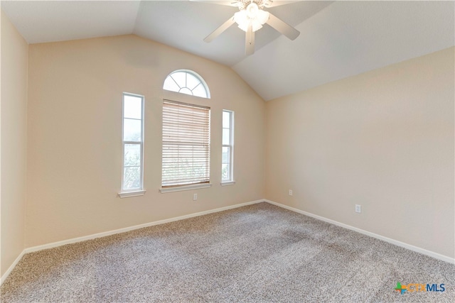 carpeted spare room with ceiling fan and vaulted ceiling