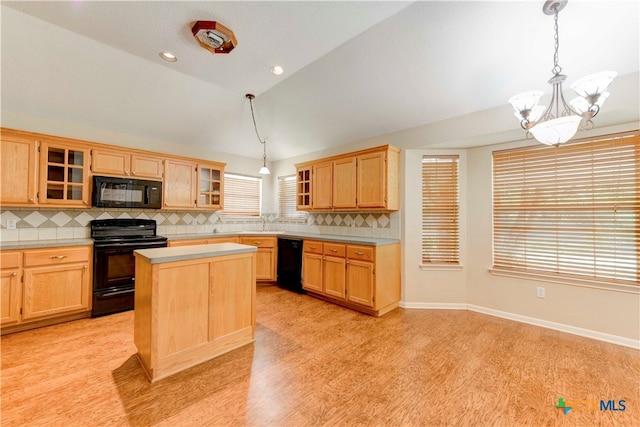 kitchen featuring black appliances, decorative light fixtures, decorative backsplash, lofted ceiling, and a center island